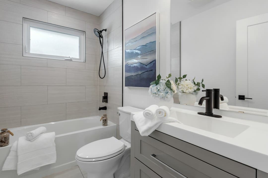 a bathroom with a toilet, sink, and bathtub — Photo by Point3D Commercial Imaging Ltd. on Unsplash