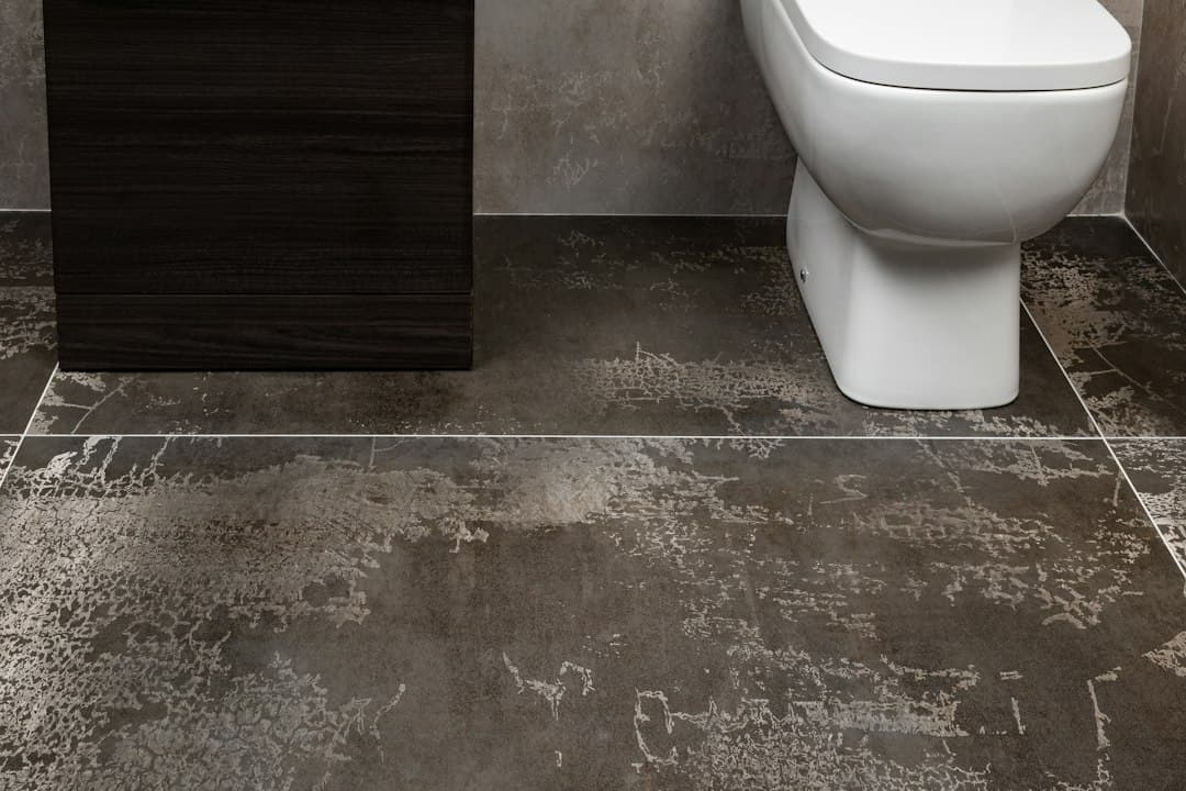 a white toilet sitting next to a sink in a bathroom — Photo by Tile Merchant Ireland on Unsplash