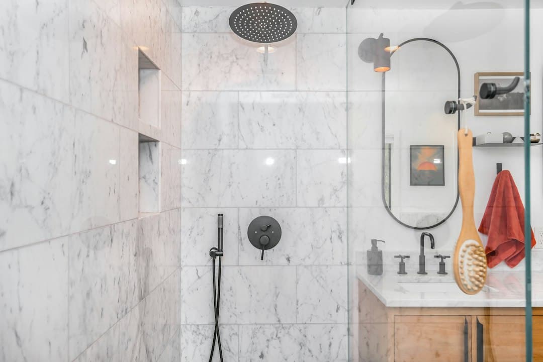black shower head on white ceramic wall tiles — Photo by Zac Gudakov on Unsplash